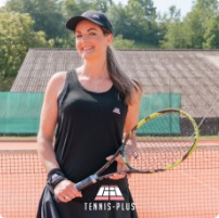 Véronique sur un court de tennis, raquette à la main